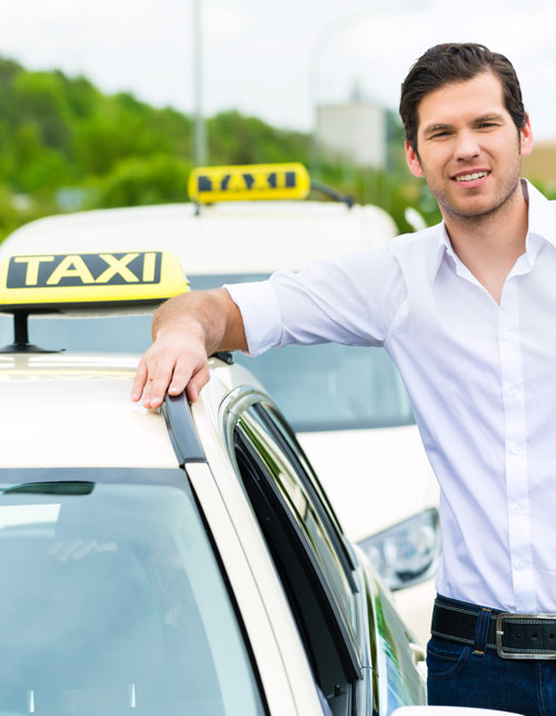 Taksiautonkuljettaja taksiautojen vieressä